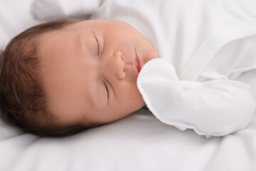 Fototapeta na wymiar Cute newborn baby sleeping on white bed, closeup