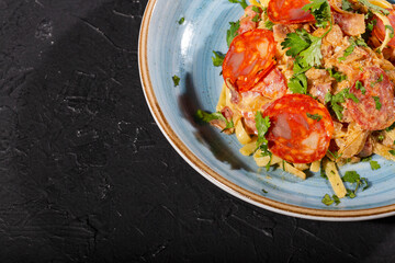 Delicious fettuccine pasta with Spanish sausage - dark background