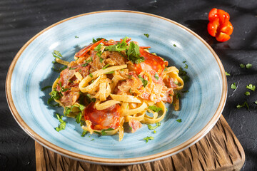 Delicious fettuccine pasta with Spanish sausage - dark background