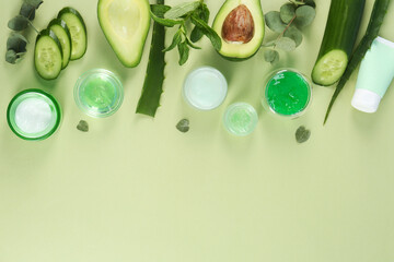 Flat lay composition with homemade cosmetic products and fresh ingredients on light green...