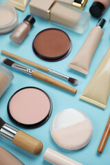Face powders and other decorative cosmetic products on light blue background