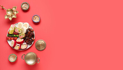 Plate with Indian treats and lamps on red background with space for text. Divaly celebration