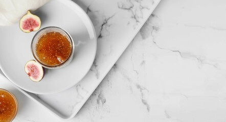Jar of sweet fig jam on white marble table. Banner for design