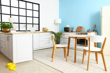 Interior of stylish kitchen with dining table and counters