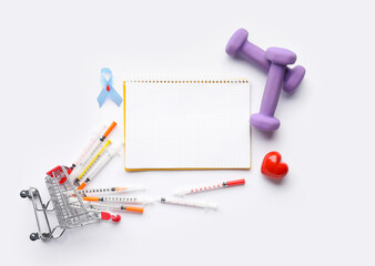 Blank notebook with syringes, shopping cart, heart, dumbbells and awareness ribbon on white background. Diabetes concept