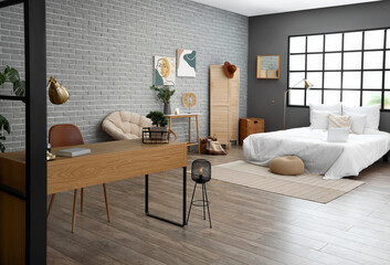 Interior of modern bedroom with bed and workplace