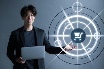 ECサイトや配送などのIT化やプラットフォーム、配送の仕組みのイメージ　黒背景の前でパソコンを持つ男性　