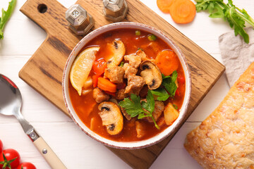 Bowl of tasty beef stew on white background