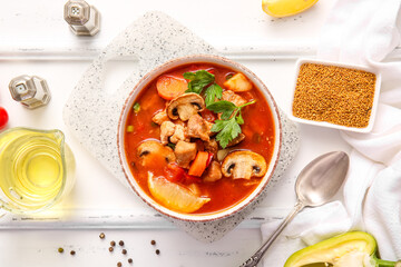 Bowl of tasty beef stew, spices and oil on white wooden background