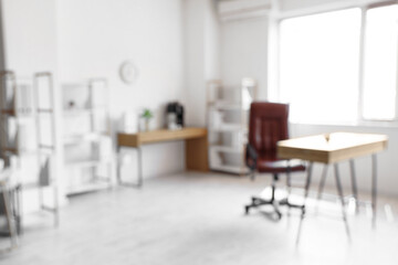Blurred view of modern light office with comfortable workplace