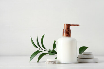 Fototapeta Bottle of shampoo and spa stones on white wooden background obraz