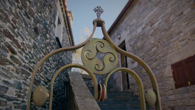 four legged triskel decoration in a well in o cebreiro galicia with shells of st james slow motion