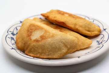 Front view Venezuelan empanadas stuffed with meat with beans and cheese on round plate on white background. selective focus. copy space