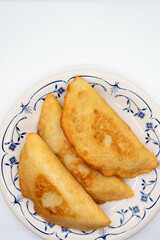 Fried empanada filled with meat. Traditional food in Venezuela and Colombia. White background, selective focus, copy space.