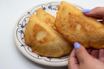 Venezuelan woman serving empanadas on a round plate, selective focus