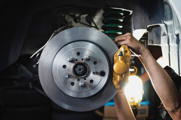 Auto mechanic installing rear brake calipers and disc brake rotors ,car rear brake repair and...