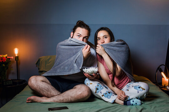 latin couple watching movie in laptop on bed at home at night in Mexico Latin America, hispanic people having fun