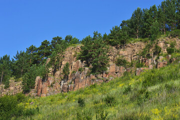 Rocky landscape in the foothills of the Sayan Mountains. Bright blue sky over the mountains on a sunny summer day.Nature of Eastern Siberia, Russia