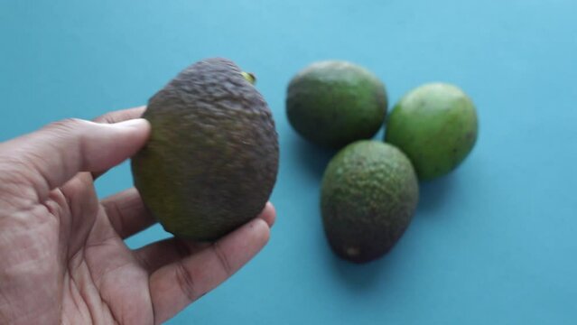  men hand pick a avocado on wooden table 