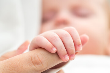 Mother's finger becomes an anchor of love. Concept of the foundational trust in newborn's world