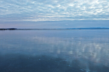Dreamy aerial view of frozen Lake Champlain in the winter with reflective ice