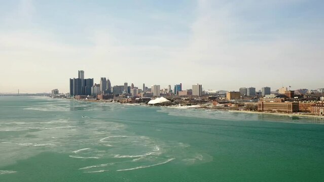 Aerial drone view of Detroit Michigan Skyline in the winter, with river and frozen ice sheets