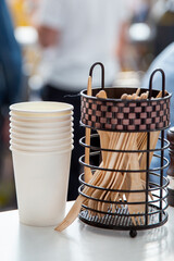 Obraz premium Stacked paper cups and set of wooden forks on table for tomorrow or lunch in a cafe