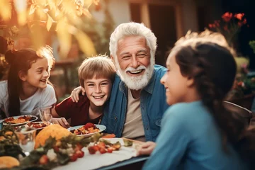 Rolgordijnen Happy Senior Grandfather Talking, eating and Having Fun with His Grandchildren, Holding Them in Lap during Outdoor © Salsabila Ariadina