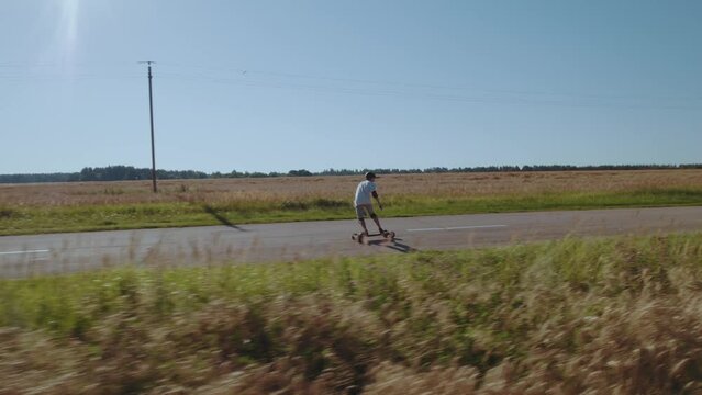 Aerial photography of a skateboarder, a man riding an electric longboard, a man riding a skateboard, traveling by electric transport