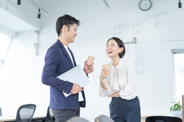 オフィスで同僚と談笑する男女