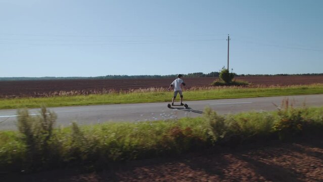 Aerial photography of a skateboarder, a man riding an electric longboard, a man riding a skateboard, traveling by electric transport