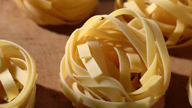 Close-up video of dried pasta on a cutting board. Tagliatelle. moving sideways.