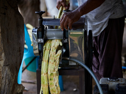 A man queezing sugarcane juice