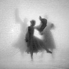 Abstract composition of dancing girls. Theater of shadows through the light with a vintage texture.
