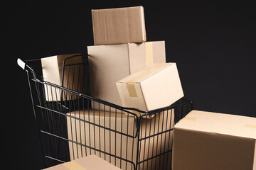 Shopping trolley with boxes and copy space over black background