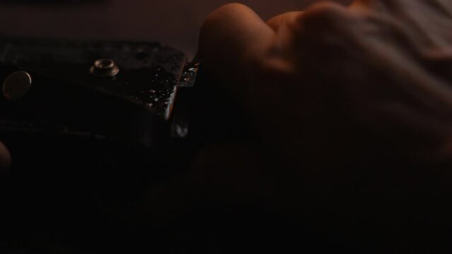 Hunting knife inserted and taken out of it&acute;s holstered in flaming light with raindrops covering the scene