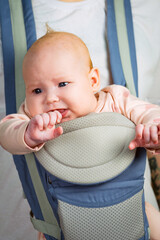 Unrecognizable dad with capricious baby in sling. Close up.