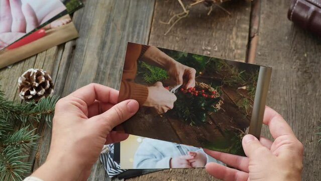 Photo printing concept. Hands browsing printed photos with Christmas holiday moments.