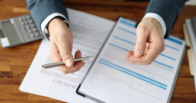 Male entrepreneur flips through pages of partnership agreement contract for signing. Man sits at table making important decision for company