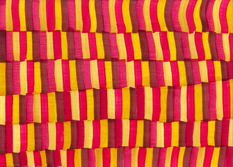 Abstract background from vertical stripes. Different shades of yellow, red, pink colors. Stripes of different sizes that are regularly repeated forming a texture. Autumn colors.