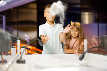 Kids playing with sand educating with interactive playgrounds in science museum. Concept of children's entertainment and learning