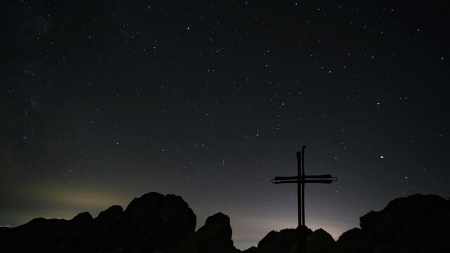 Milky Way and stars moving in the night sky above the cross, time-lapse video 
