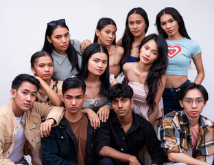 A diverse group of eleven young asian college students posing together looking serious. 6 women, 4 guys and 1 trans woman. Isolated on a white background.