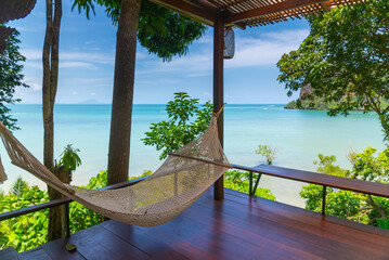 Dramatic view overlooking sea cloud boats from wooden hut resort hotel in Krabi, Thailand.