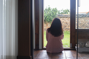 a woman sitting on the floor of a korea traditional house