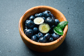 A bowl of blueberries. Fresh berries and leaves. Vitamins and berries. Top view.