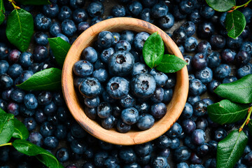 A bowl of blueberries. Fresh berries and leaves. Vitamins and berries. Top view.