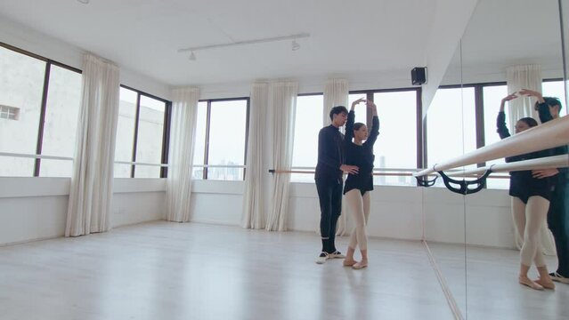 Young beautiful dancers practicing ballet performance during rehearsal at the studio. They doing classical jumping steps, then boy lifting girl up in the air