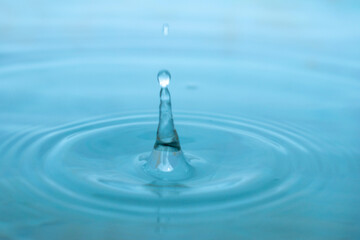 Water drop. Close-up circle ripples on water surface. Clear Water drop with circular waves