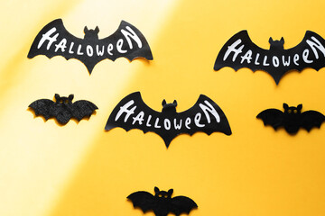 Halloween concept. Black paper bats on orange background. Top view.Halloween pumpkins and bats on orange background. Top view.